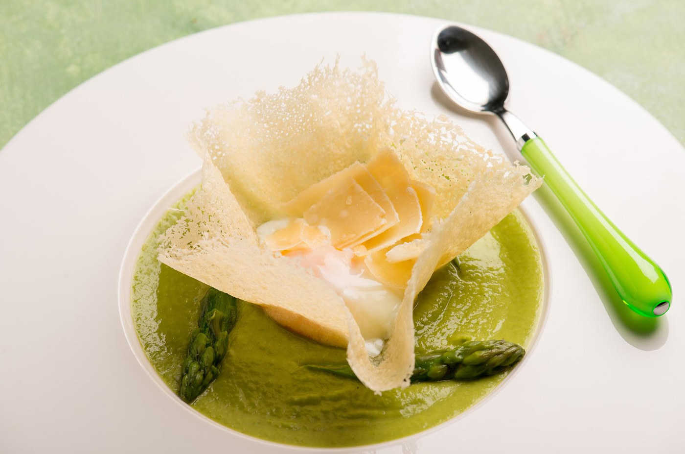 Cestini di parmigiano con uovo in camicia su crema di asparagi