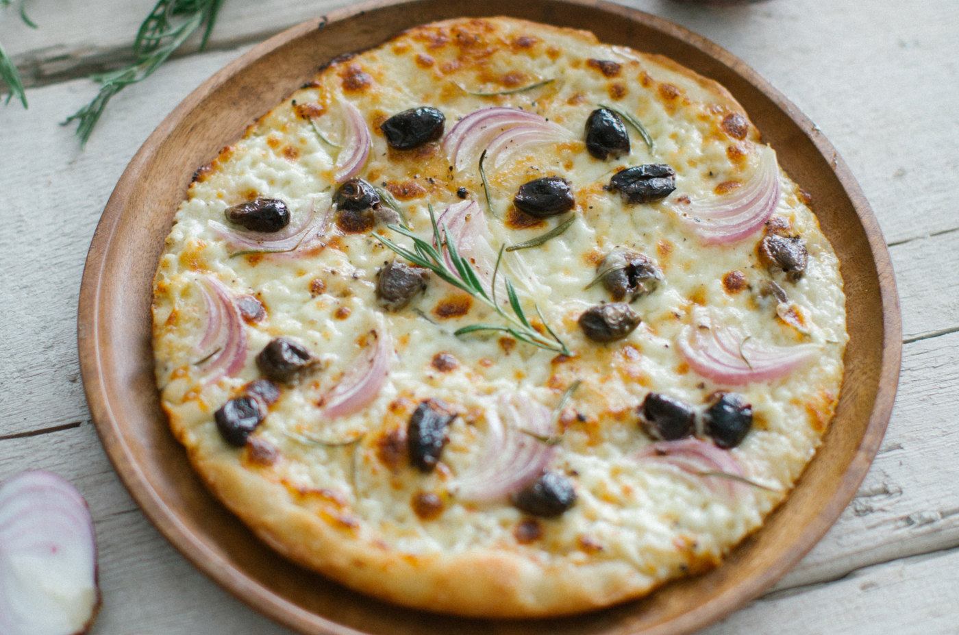 Pizza con stracchino, olive taggiasche, cipolla rossa e rosmarino